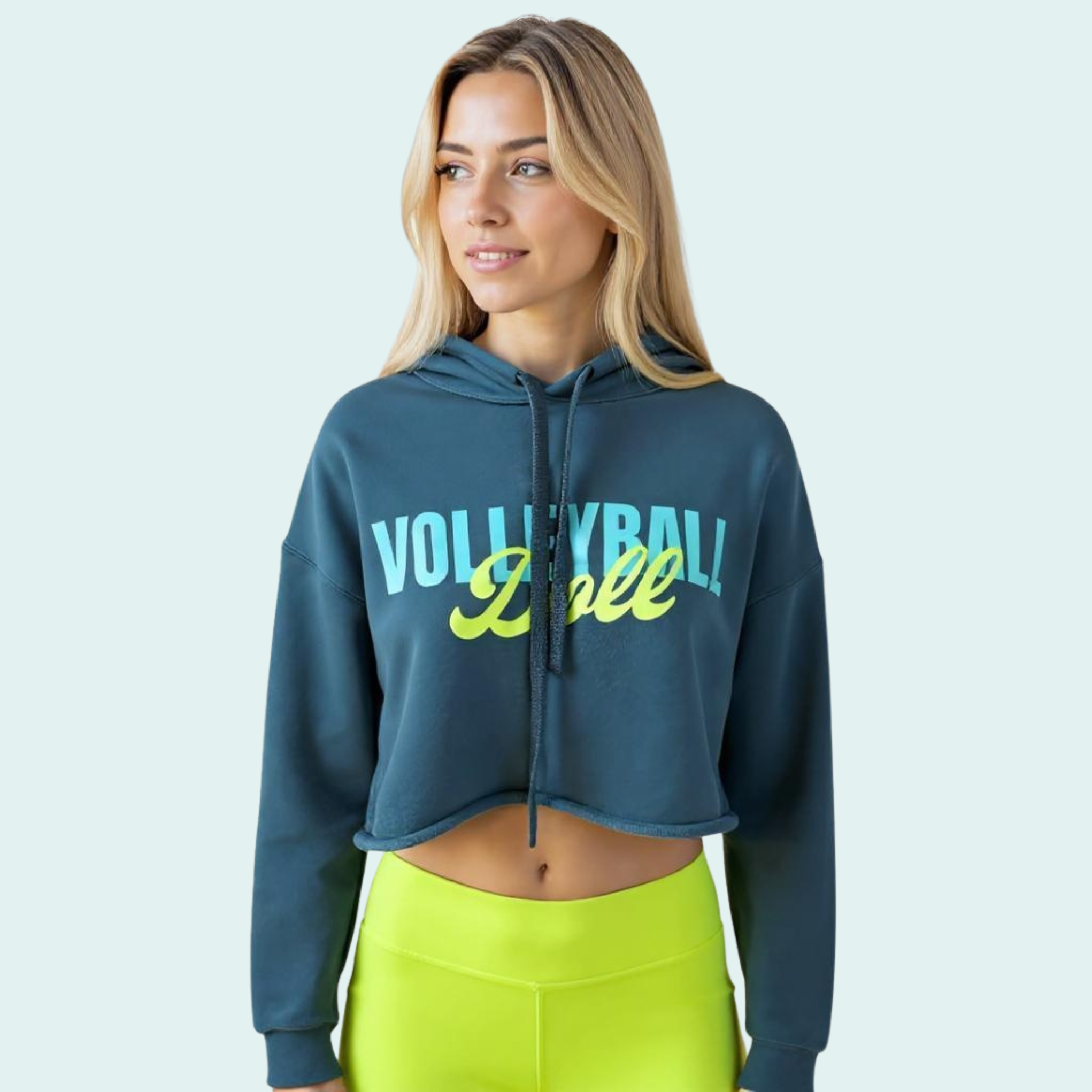 Female wearing a blue-green cropped hoodie with 'Volleyball Doll' text in bright light blue and yellow-green text across the front
