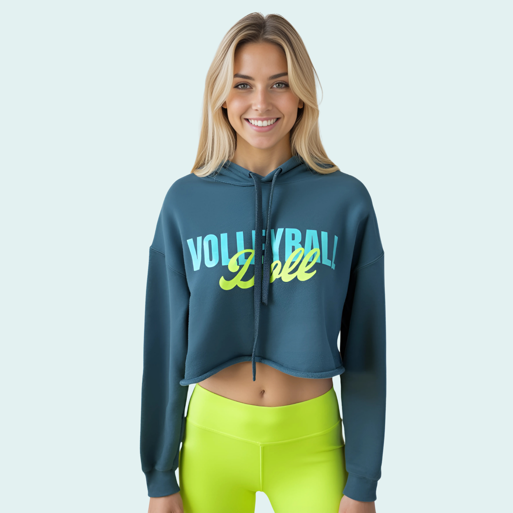 Female wearing a blue-green cropped hoodie with 'Volleyball Doll' text in bright light blue and yellow-green text across the front 