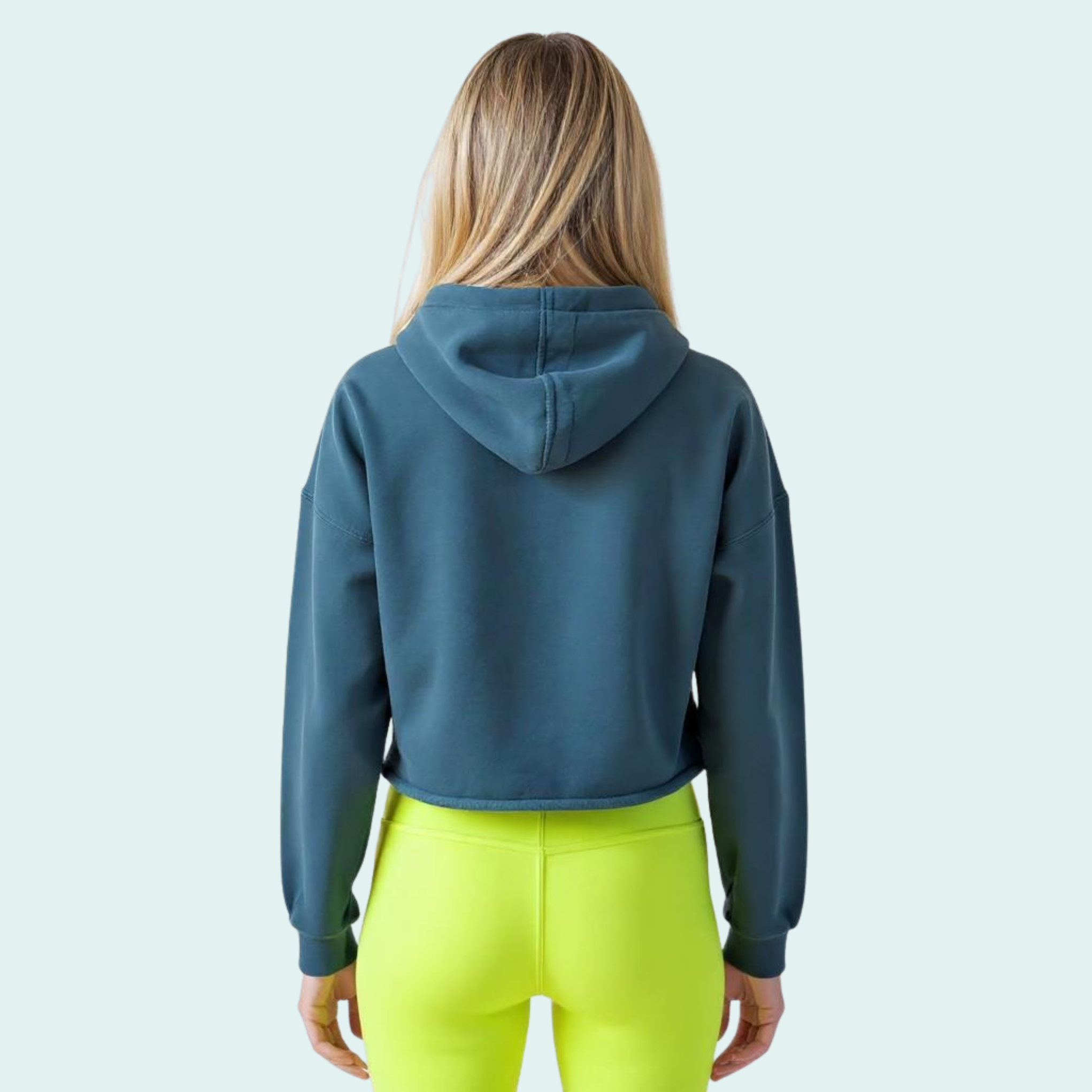Female wearing a blue-green cropped hoodie with yellow-green volleywalls logo near the neckline on the back.